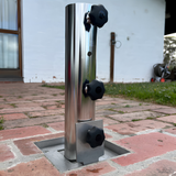 EzyHold Insert 316 marine-grade stainless steel flush-mount umbrella holder installed into a brick paver courtyard with the tri-knob stabilizing sleeve attached.