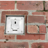 Top-down view of an EzyHold Insert flush-mount umbrella holder base installed in brick pavers, shown next to its matching brick-filled insert lid.