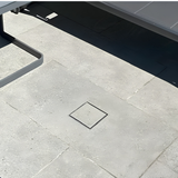 EzyHold Insert flush-mount umbrella holder completely closed with a matching concrete paver insert lid, creating a seamless and trip-free patio floor surface.