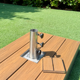 EzyHold Insert 316 marine-grade stainless steel flush-mount umbrella holder installed into a timber deck with the removable stabilizing sleeve attached and the matching decking-insert lid placed alongside it.