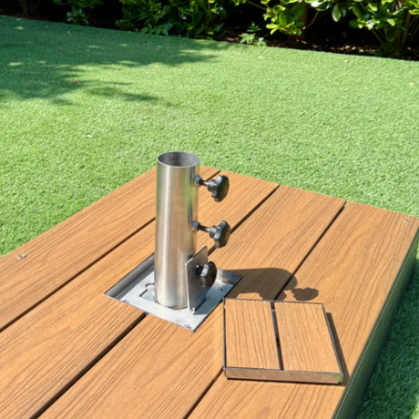 EzyHold Insert 316 marine-grade stainless steel flush-mount umbrella holder installed into a timber deck with the removable stabilizing sleeve attached and the matching decking-insert lid placed alongside it.