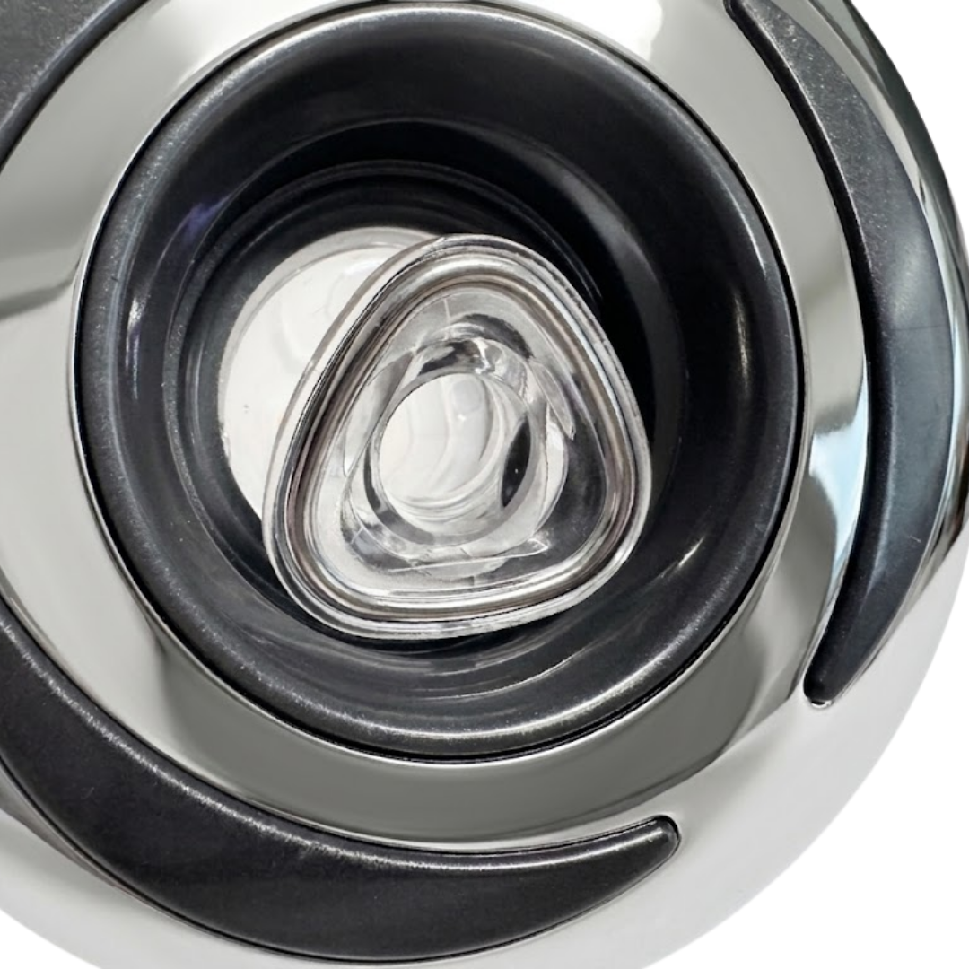 Extreme close-up view of the clear rotational nozzle on a Helix 4.5 ROTO stainless steel spa jet internal insert, showing its triangular outer lip and inner fluid channel within a dark grey bezel.