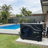 An outdoor swimming pool heat pump by insnrg placed on a concrete pad next to a residential backyard pool and deck.