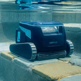 Underwater front lifestyle view of the Maytronics Dolphin Liberty 600 robotic pool cleaner parked on stone pool steps near the water surface.