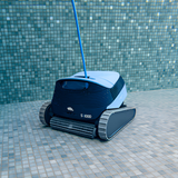 Maytronics Dolphin S1000 automatic pool cleaner scrubbing the floor of a mosaic tiled swimming pool underwater