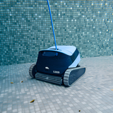 Maytronics Dolphin S2000 robotic pool cleaner operating underwater on a tiled swimming pool floor with its blue cable attached.