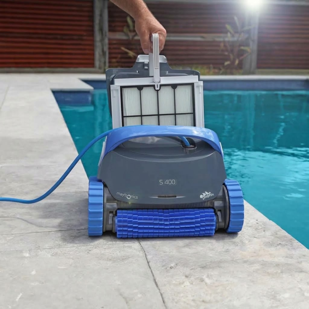 Front close-up view of a hand pulling the top-access fine filter basket out of a dark grey and blue Maytronics Dolphin S 400 robotic pool cleaner on pool paving.