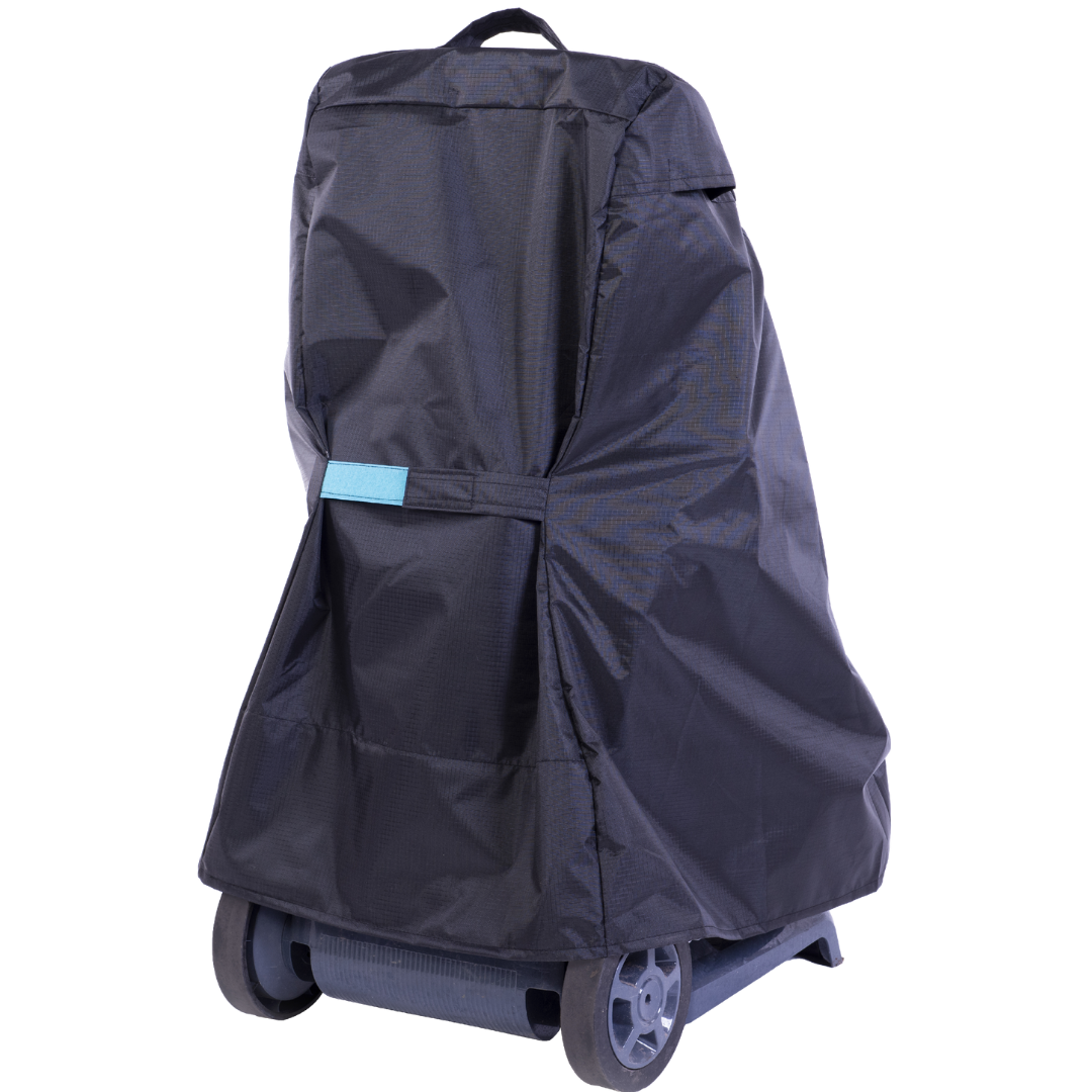 Rear three-quarter studio view of a black weather-resistant protective cover draped over a Maytronics Dolphin pool cleaner transport caddy on an isolated white background, detailing its light blue securing tab strap, top grab handle, vented upper seams, and exposed dark grey caddy base with dual wheels.
