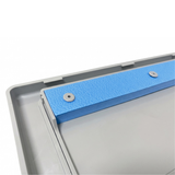 Close-up view of the texturized blue buoyancy foam block secured with round plastic rivets to the back of a grey pool skimmer weir flap door