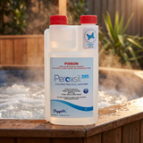 A 1L bottle of Poppits Peroxsil 395 Chlorine Free Pool Sanitiser on the edge of a steaming timber hot tub, featuring the Sensitive Choice blue butterfly logo for asthma and allergy care.