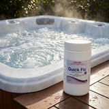 A 1kg container of Poppits Quick Fix chlorine-free spa oxidiser sitting on a wooden side deck next to a steaming, bubbling outdoor hot tub spa.