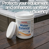 A 1kg tub of Poppits Water Balance pool and spa chemical on a wooden deck next to a hot tub. The label states it contains 99-100% Sodium Bicarbonate and is used to raise pH and Total Alkalinity to protect equipment and enhance sanitiser efficiency.