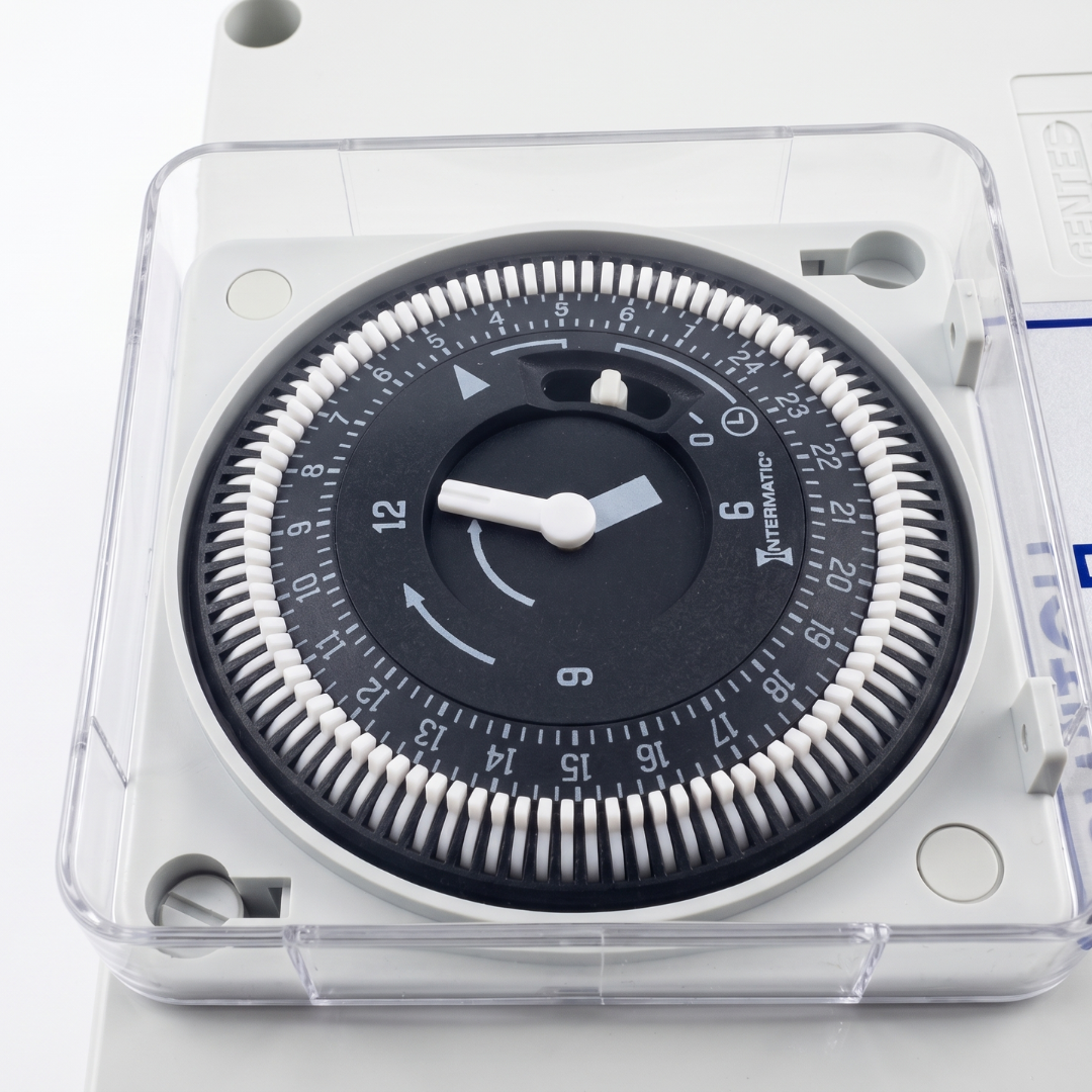 Close-up macro shot of the Intermatic 24-hour analog timer dial with white segment pins inside the Space Age Electronics AS02-T air switch controller.