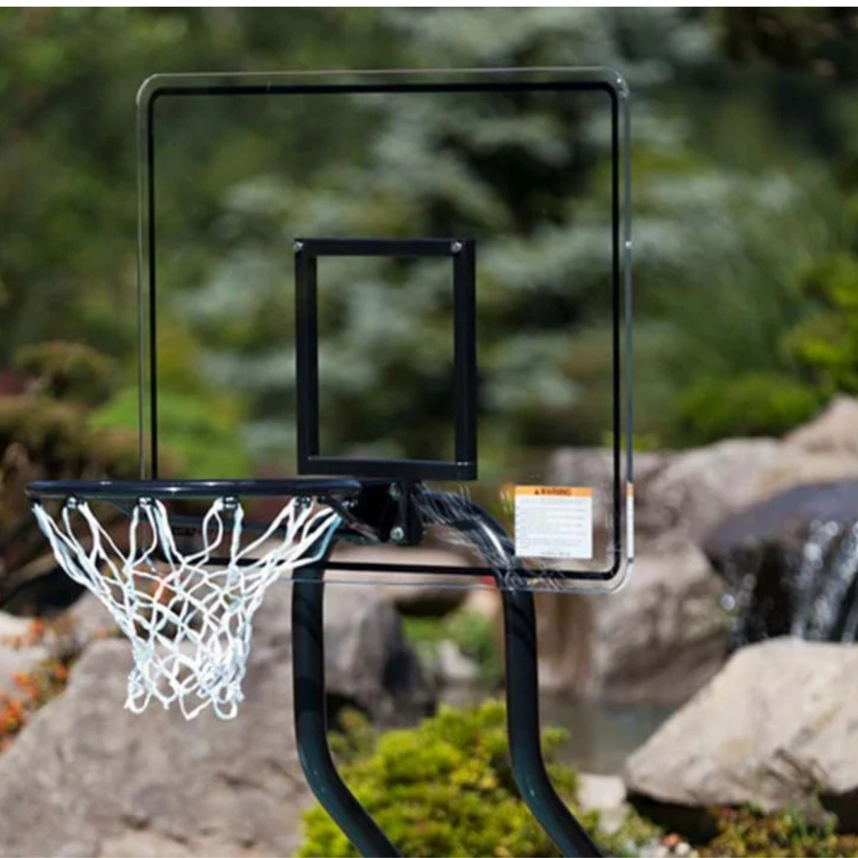 Close-up of an S.R. Smith Challenge commercial pool basketball system showing the clear acrylic backboard, black vinyl-coated frame, and rim with net.