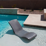 An empty S.R. Smith Destination Series in-pool rocking lounge chair in Starry Night dark grey finish sitting on a shallow pool sun shelf.