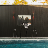 S.R. Smith Swim-N-Dunk pool basketball hoop installed poolside against a modern black slatted wall with water fountains