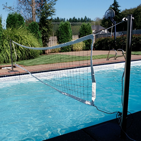 Outdoor lifestyle photo showing the S.R. Smith Swim N' Spike volleyball net stretched across a backyard residential swimming pool, anchored into deck posts.