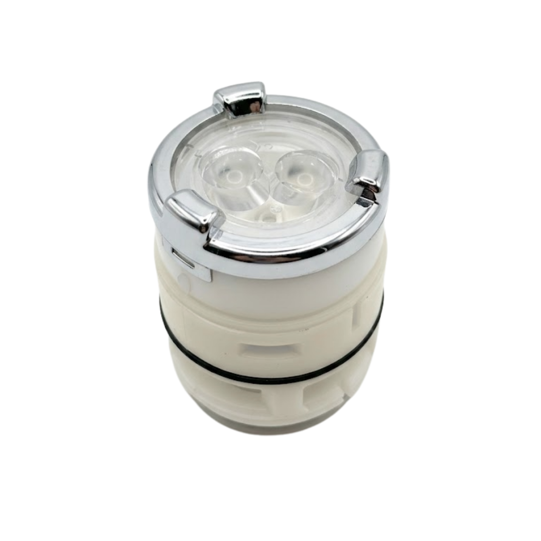 Three-quarter top view of a replacement swirl spa jet internal insert featuring a polished chrome outer trim ring with three raised tabs, a clear plastic face with twin nozzles, and a off-white cylindrical body with an O-ring seal.