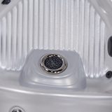 Close-up view of a single Ultra Blaster 7 SS Graphite spa jet installed in the raised footwell dome of a silver acrylic hot tub shell.